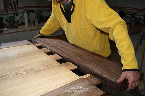 Earl inserting mortise and tenon ends of custom made dining table